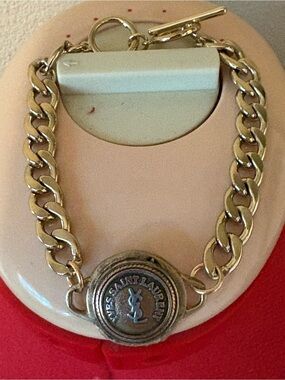Authentic YSL charm on unbranded bracelet chain with toggle clasp.